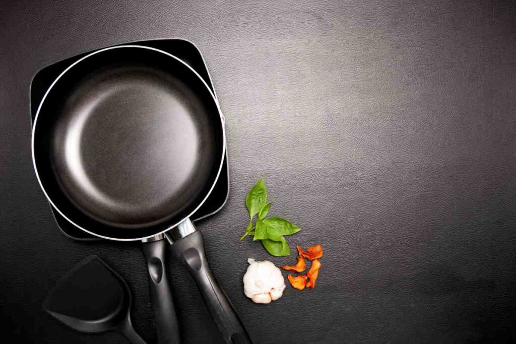 Top view frying pan and pot on black table